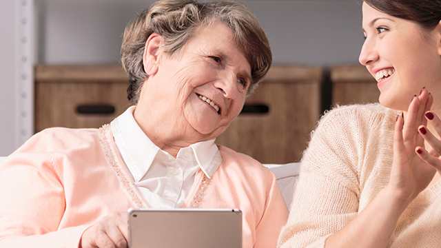 elderly woman using aged care technology with a big smile