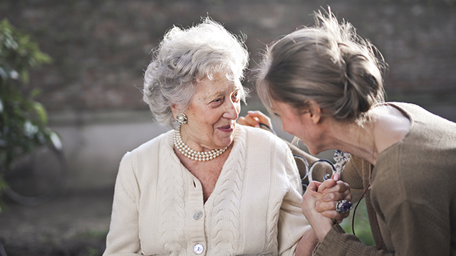 elder woman happily chatting with daughter