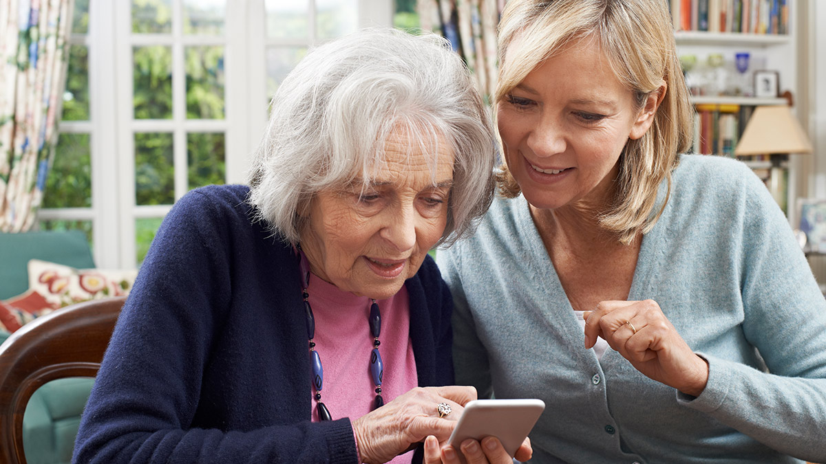 elderly woman learning how to use the InteliCare app